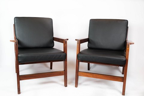 A pair of lounge chairs in polished wood and black classic leather of danish 
design from the 1960s.
5000m2 showroom.
