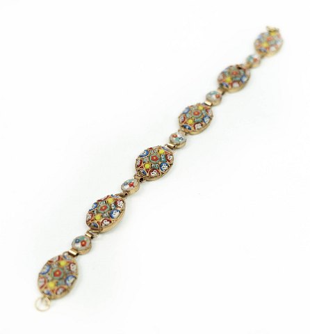 Leddelt armkæde dekoreret med forskellige farver, af forgyldt metal.
5000m2 udstilling.